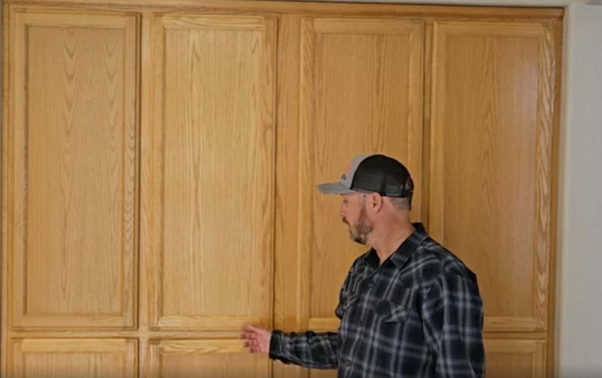 Contractor in front of cabinet doors